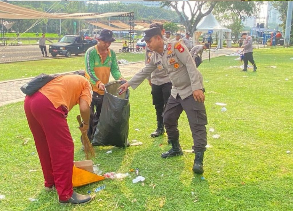 Polres Metro Jakarta Pusat Turun Tangan Bersihkan Sampah Usai May Day di Monas